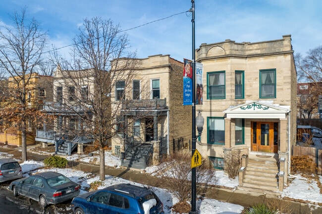 Brick two flats line the streets of Ravenswood behind maturing trees.