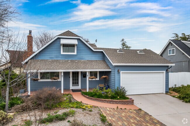 This Cape Cod style home in Swanston Estates has a 2-car garage and brick walkway.