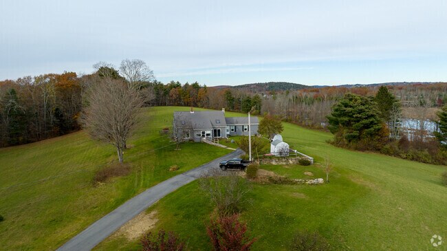 A cape style home sits atop a hill surrounded by green space in East Brookfield.