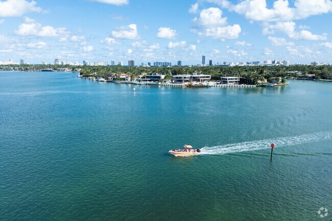 A lush green island with residential properties overlooking the water in Bayshore.