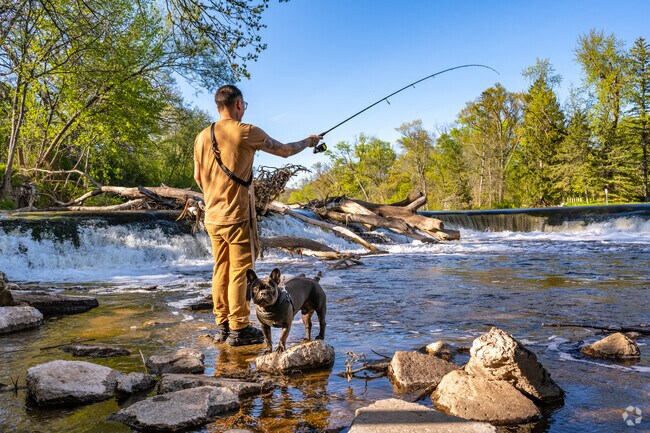 A man with his dog wait for a bite while fishing in the Milwaukee River in Nicolet.