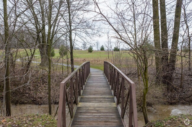 A trail bridge crosses over a creek running through Creekside Park.