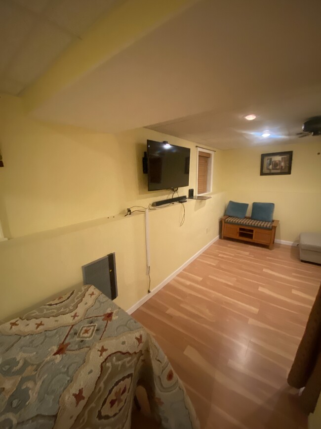 living space w/ provided furnishings , seater, and TV