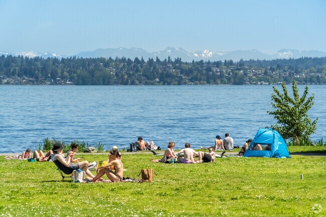 Bryant locals enjoy a stunning day getting a sun tan at a beach in Magnuson Park.