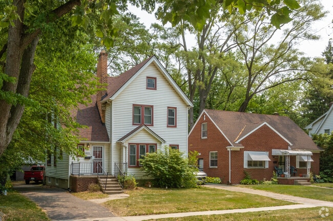 New England colonial-style saltbox home neighbors a brick cottage home in The Eye Neighborhood.
