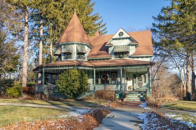 A sage green Victorian style home in West Springfield has a large wraparound porch.
