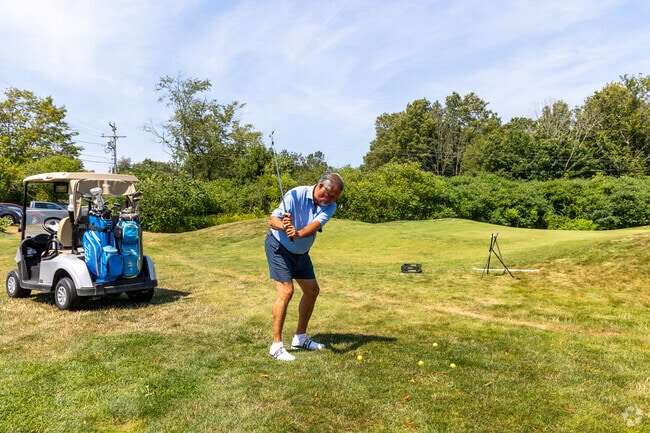 A member of the privately owned Portsmouth Country Club practices their swing on the course.
