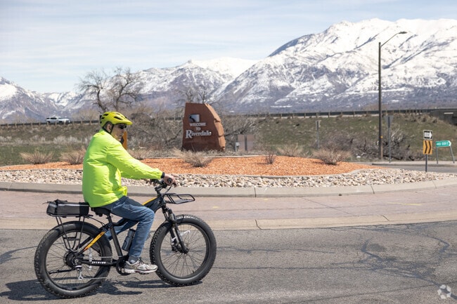 Man Riding a Bike in Front of the Welcome To Riverdale Sign at W 4400 S, Riverdale, UT 84405