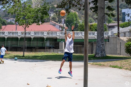 A player makes a jumpshot during a practice at the Verdugo Park basketball courts.