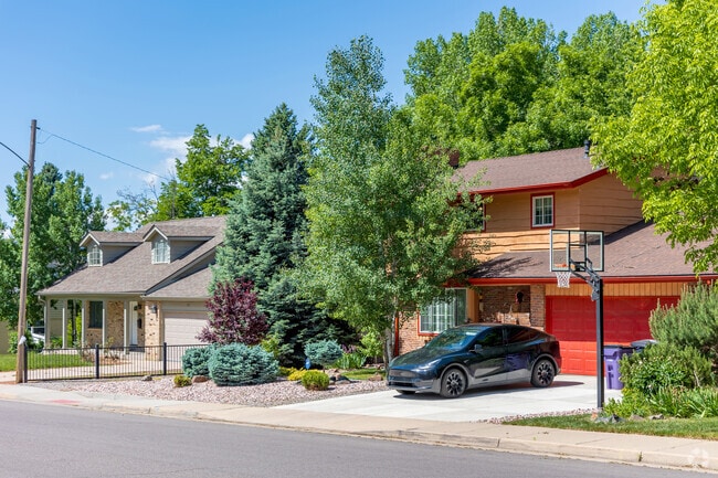 Mature trees shade front lots and paved driveways in the Bear Valley neighborhood.