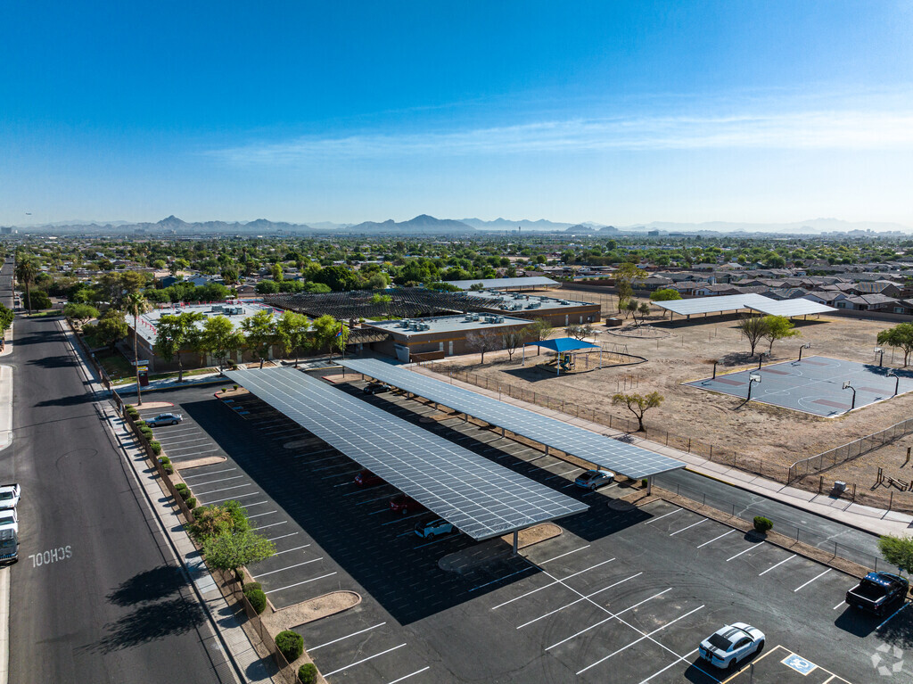 Contextual view of John F Kennedy Elementary with parking lot.