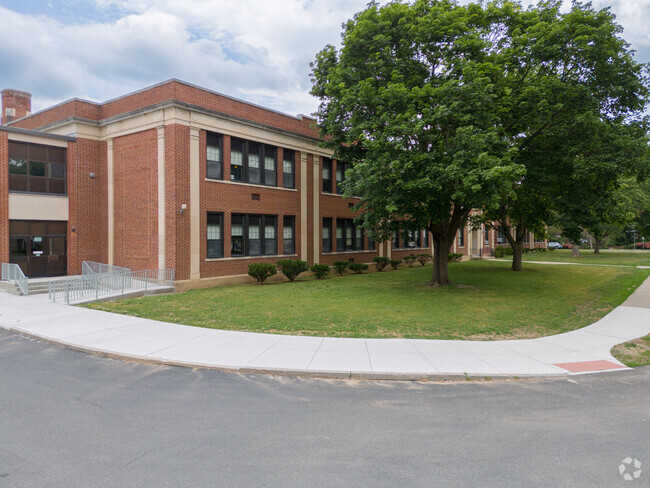 The Sacandaga Elementary School is surrounded by large beautiful trees on all sides.
