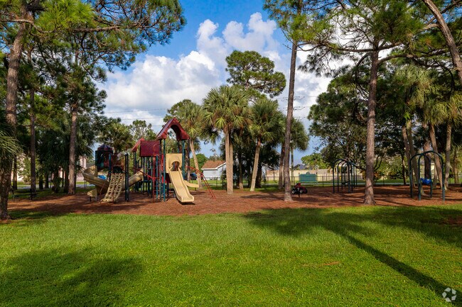 The Heights of Jupiter Park has swings and a jungle gym with multiple park benches.