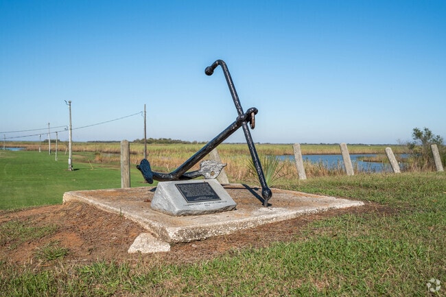 A decorative anchor display sits along the waterfront in Anahuac, Texas.