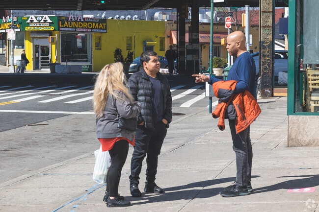 Friends meetup on the street for chats in Middletown-Pelham Bay.