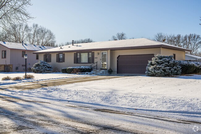 This Ranch style home has brown shutters.