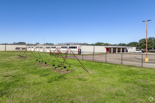 Students enjoy a colorful playground and a basketball court for recreation.