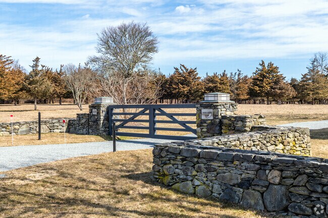 Beavertail homes feature stone fencing and custom gates with lighting accents.