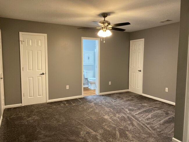 Upstairs carpeted master suite has walk in closet, full bath, ceiling fan and access to two walk in attic storage areas.
