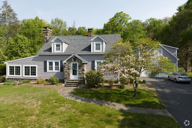 A modern Cape Cod has a custom stone entranceway in East Riverton.