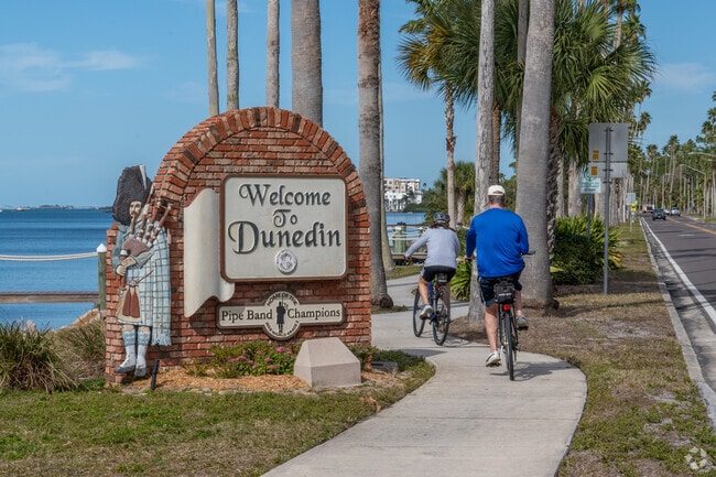Cyclists pass by the Dunedin signage.