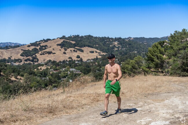 A man walks along the Acalanes Ridge Trail, taking in the scenic beauty of Walnut Creek.