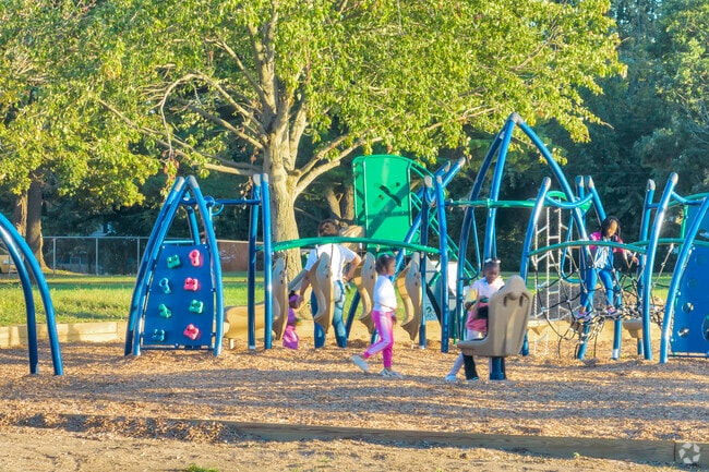 Kids play on the swings at Garfield Park's playground near the Martin Luther King area.