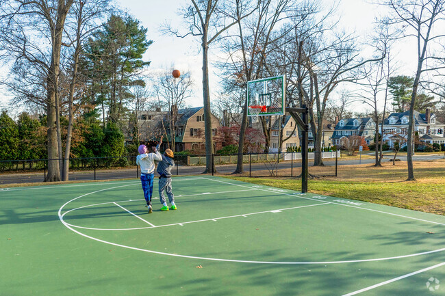 Folks play basketball at a court in Elizabeth Park in West End.