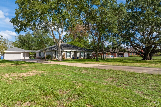 Tree-lined streets enhance outdoor comfort for Manvel homeowners.