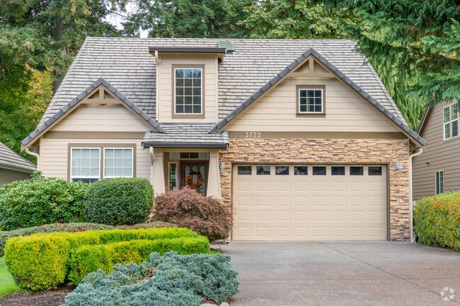 Two-story home with a welcoming porch, lush garden, and colorful shutters in Indian Summer.