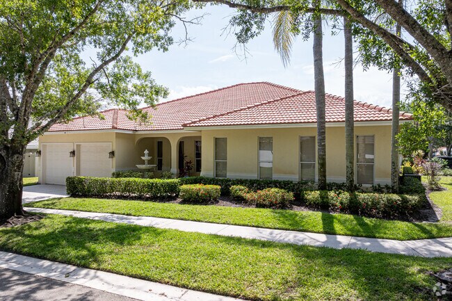 Mediterranean-style homes line gently winding streets, shaded by oak trees, in The Shores.