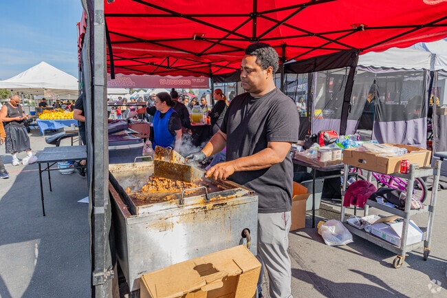 Local vendors prepare fresh food at the Compton College farmers market.