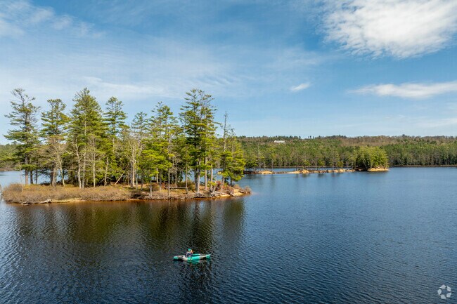 A birdwatching kayaker glides across the calm waters of Tully Lake in Royalston.
