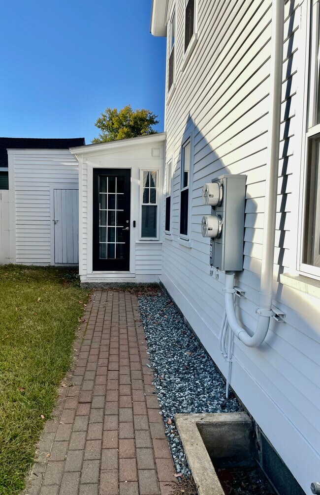 A view of the Unit 2 side yard and private entrance from the driveway.