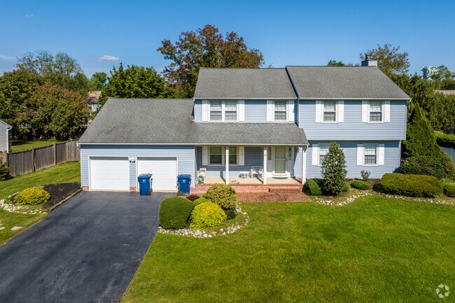 Two-story colonial homes in Lawrenceville are surrounded by mature trees.