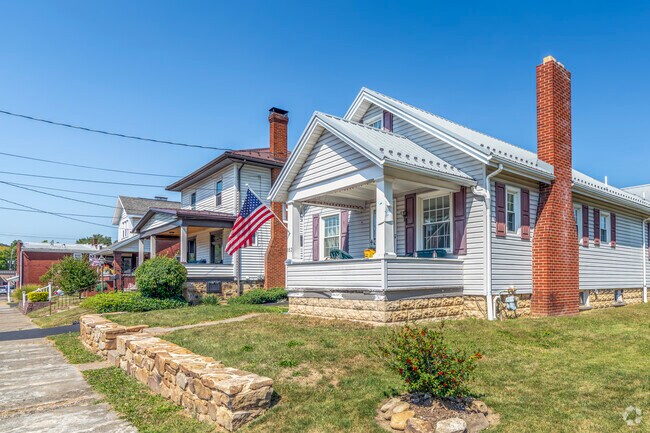Many homes on Broad Avenue are decorated with wreaths, American flags, and trimmed shrubs.