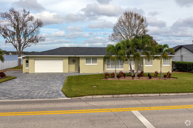 This Lake Conway waterfront home features a paver driveway and tasteful landscaping.