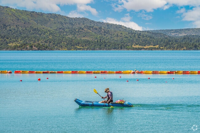 A kayaker enjoys a sunny day on the crystal clear waters of Nighthorse Lake.