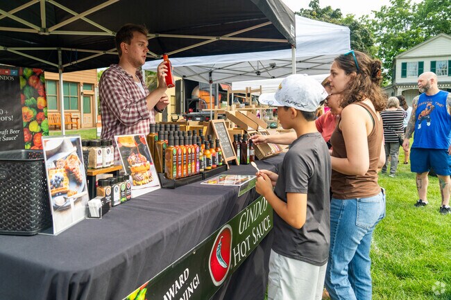 Local shoppers learn of the different varieties of hot sauces from Gindo's Hot Sauce.