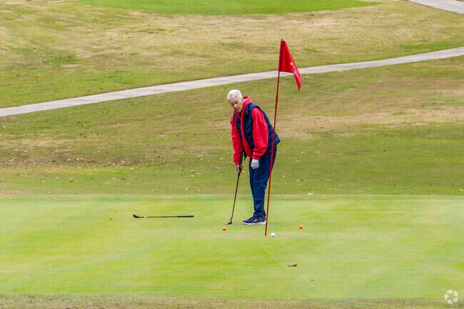 A golfer takes a putt on the green at University Golf Club in Gardere.