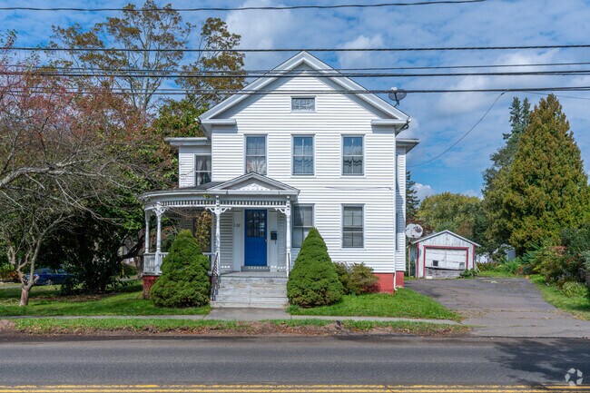 Picturesque Colonial style home in Guilford with a vibrant blue door and a cozy porch.