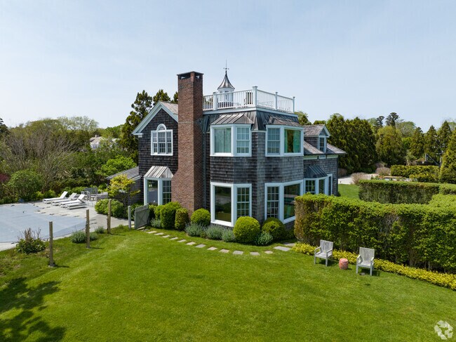 A new Traditional Craftsman-style home in  East Hampton features a pool.