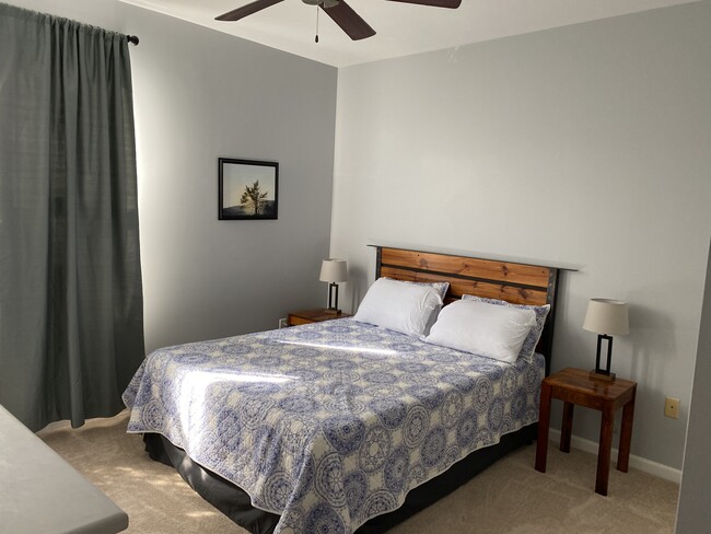 Inviting Bedroom with queen bed, two nightstands, lamps, two closets, dresser