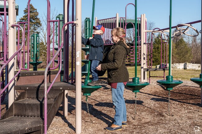 A young boy gets some help negotiating the climber at Woods Haven Kruse Park.
