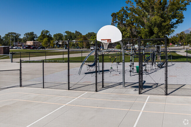 The fence surrounding a basketball court provides a view to a playground at New Bridge School.