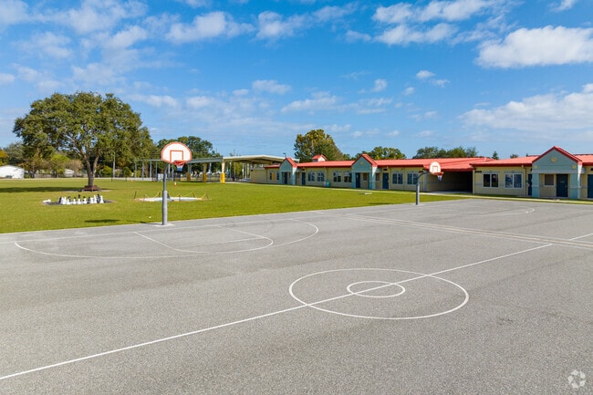 The large open basketball court and grass field allow students ample space during recess.