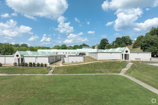 Green Pines Elementary has a unique appearance with a white stone facade and a green metal roof.