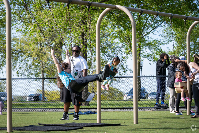 Children delight in the Kennedy Park playground, swinging at the Sandy Beach neighborhood.