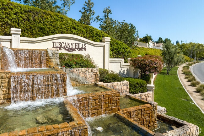 Waterfalls and blue skies are seen at the entrance to the Tuscany Hills Neighborhood.