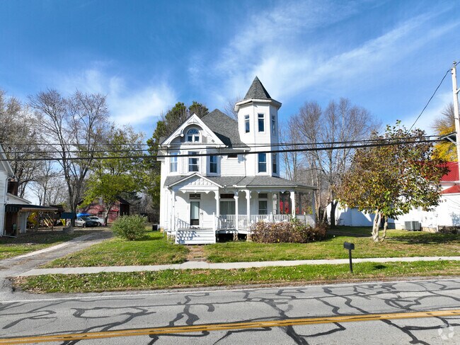 A large white Victorian home stands prominently on the corner of Main Avenue in Sardinia.